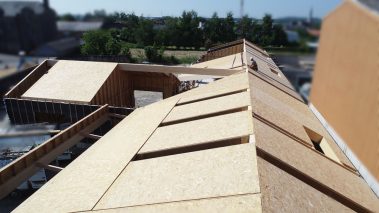 Le nouveau pôle enfance de la commune d'Issu prend forme. La charpente de la toiture est en train d'être posée.