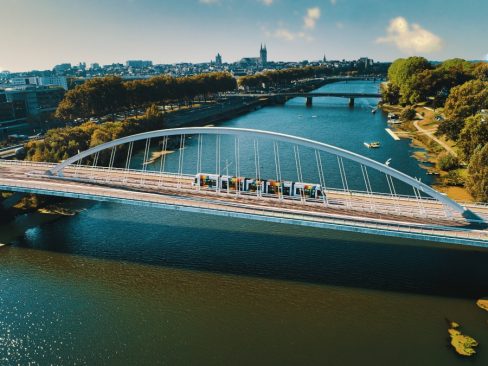 Prises de vues aériennes du Pont Confluences à Angers. On voit le tramway d'Angers avec ses couleurs arc-en-ciel caractéristiques passer sur le pont en enjamber la Maine.