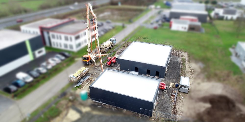 Suivi de chantier- Haute goulaine- Coulage de la Dalle- Fev 19 Dans cette prise de vue aérienne, on voit désormais les deux bâtiments, dont le bardage vient d'être installé. Place désormais aux installations intérieures, avec le coulage de la dalle.