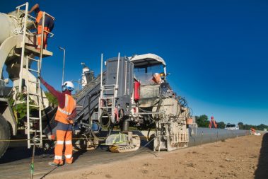 Les consignes sont données par les hommes en orange. Le béton est coulé à même le chantier. Ils avancent de 600 ml par jour. C'est impressionnant.