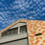 prise de vue de la nouvelle école de musique de Treillières en Loire Atlantique. Une façade toutes en écailles jaune, orangeavec des beiges plus clairs donnent un aspect très particulier. On adore.