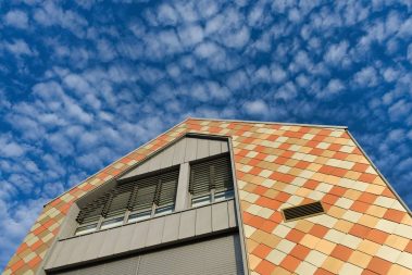 prise de vue de la nouvelle école de musique de Treillières en Loire Atlantique. Une façade toutes en écailles jaune, orangeavec des beiges plus clairs donnent un aspect très particulier. On adore.