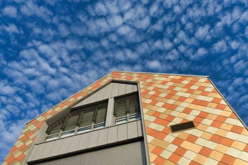 prise de vue de la nouvelle école de musique de Treillières en Loire Atlantique. Une façade toutes en écailles jaune, orangeavec des beiges plus clairs donnent un aspect très particulier. On adore.