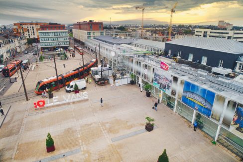 Suivi de chantier par drone à la gare du Mans. Prises de vues aériennes pour la filiale d'Engin, à savoir Axima, en charge de la réfection d'une partie des toitures. La photo a été prise depuis le parvis de la gare avec les services de sécurité. On y voit l'entrée de la gare ainsi que les fameux tramway oranges ainsi que les bus de la même couleur. A cette heure matinale le parvis de la gare est encore bien seul. Il faut dire que c'est l'a période des vacances, mais également d'une grève.