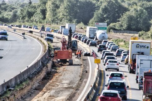 Création d'une tranchée dans le terre plein central de la RN 165. La circulation est dense. Les ouvriers sont masqués en raison de la situation sanitaire
