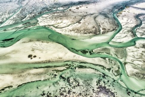 L'estran de la baie de Quiberon laisse apparaître de biens étranges formes. L'eau a creusé des sillons dans lesquels s'engouffrent des bras d'eau coloré. Les quelques cailloux couverts de moules, bigorneaux et quelques teintent de foncés le fond de la photo et donne un aspect quasi dramatique à celé-ci