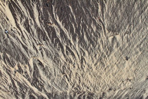 Un mélange de déchets végétaux mélangés au sable donne cet aspect à cet arénaglyphe. La photographie a été prise à Essaouira au Maroc