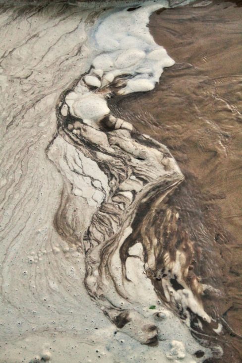 Un visage est dessinée dans l'écume en bord de mer dans le Morbihan.