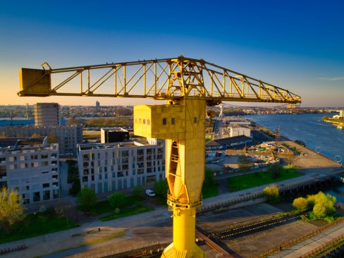 La grue Titan Jaune de Nantes, symbole historique de la cité des Ducs illumine le ciel bleu nantais. Le lever de soleil lui donne des teintes douces.