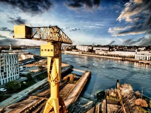 La grue jaune à Nantes marque l'entrée de la ville en empruntant la Loire. Son ombre plane sur le fleuve le plus long de France