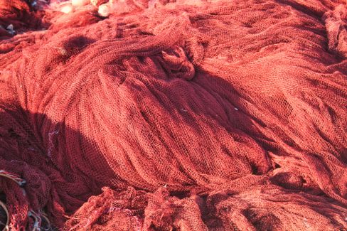 Un filet de pêche est en train de sécher et d'être nettoyé sur le quai