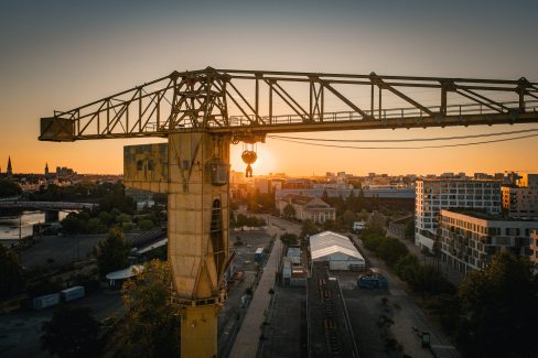 Le soleil se lève derrière une poulie de la grue jaune sur l'ïle de Nantes.