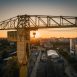 Le soleil se lève derrière une poulie de la grue jaune sur l'ïle de Nantes.