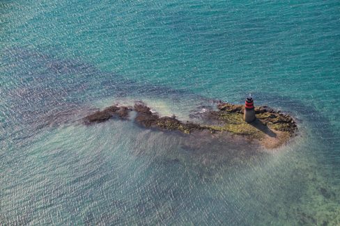 Un phare perdu au milieu de la Manche, entre Avranches et Le Mont St Michel signalent aux usagers de la mer la présence de roches. L'eau est peu profonde car cette dernière est très clair. Les parties sombres de la photo indiquent la présence de roche et donc d'algues qui s'y sont développées.