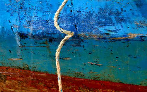 Une corde de bateau, un bout comme on dit s'est entortillé sur la coque bleu et rouge d'un bateau.