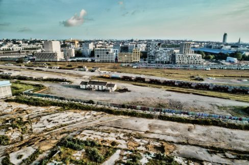Prises de vues aériennes et suivi de chantier sur Nantes. Il ne reste guère que cet ensemble au milieu d'un friche industrielle. Une petite bicoque au milieu des rails et quelques TER stationnés comme décor. Nous l'appellerons la maison de l'aiguilleur. Il ne reste qu'elle et elle paraît bien petite à côté des immeubles du fond à l'architecture moderne et qui pousse un peu partout. Le MIN s'en est allé pour faire place à un nouveau CHU.