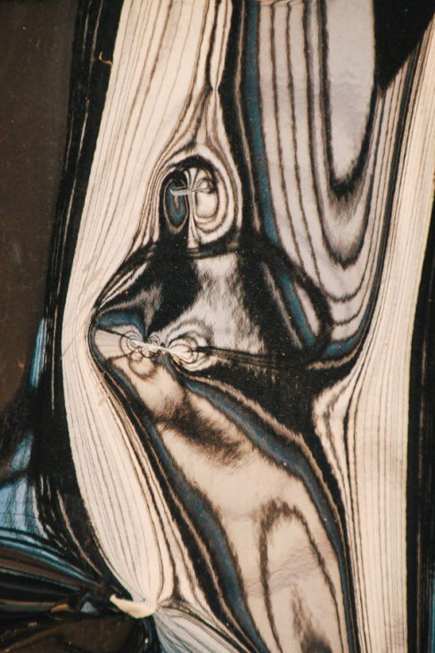 Une carrosserie se tord et donne des irisations de couleurs bleu et crème. La torsion des alliages fait apparaitre, le temps d'un instant, comme des parenthèses, des formes. certains voient un moine, un super héros et d'autres ne voient due des lignes qui s'entrecroisent.