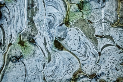 De l'écume laisse dans une marre d'eau des formes étranges, des visages apparaissent