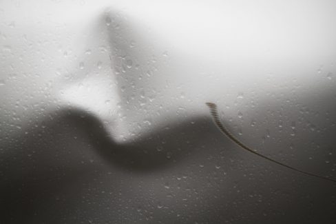 des parenthèses avec des tons blanc crème et gris. Les plis de la structure donnent naissance à une forme qui ressemble à un nez.