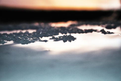 De l'eau à geler sur une carrosserie de voiture formant des glaçons. Le soleil se lève et se reflète d'une manière douce sur le capot et donne cette atmosphère étrange à cette photo. Des parenthèses comme on aime savourer.