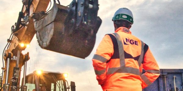 Excavation Suivi de chantier sur Nantes. Un conducteur de travaux de chez NGE contrôle les travaux d'excavation d'une pelle. Un camion-benne bleu est à côté de la pelle et reçoit de la terre