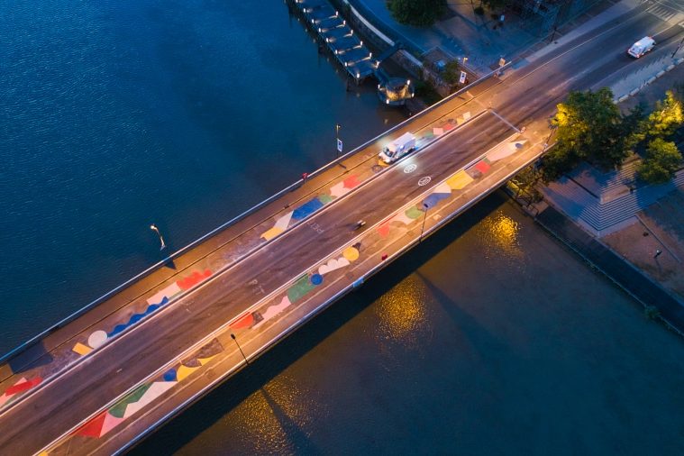 Suivi de chantier sur le pont Anne de Bretagne pour le compte de la société Esvia. Imaginé par le collectif les "feebles" . Le but ? Matérialisé par des dessins les pistes cyclables et ainsi laisser les mobilités douces s'installer. Sur cette photographie aérienne, au petit matin, les équipes de la société de marquage sont en train d'appliquer les résines de couleurs différentes.
