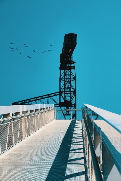 La grue noire sur un fond bleu électrique (le ciel) depuis le ponton menant à l'embarcadère du Navibus et du Passe-Partout. Ce dernier fait désormais partie du voyage à Nantes