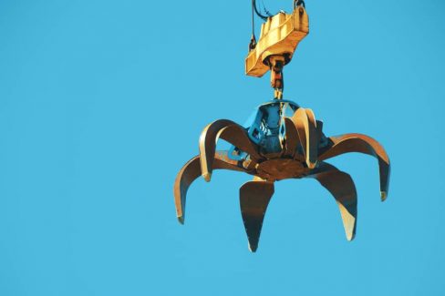 Sur le port industriel de Nantes, les griffes d'une grue s'apprêtent à charger des débris métalliques pour un long voyage.