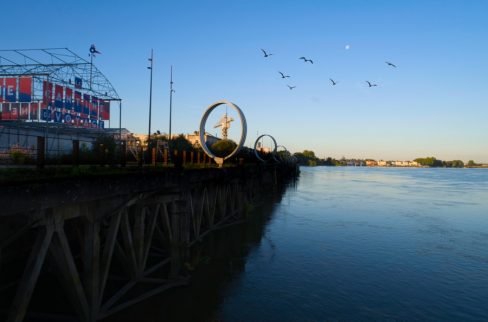 Une vue originale depuis le Loire de la Cantine du Voyage et les anneaux de Buren. Dans un de ces cercles, on aperçoit la grue Titan grise