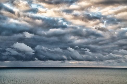 Les nuages s'approchent du rivage. Ils assombrissent la mer et laissent deviner le grain qui se profile. Les couleurs sont dramatiques et la quantité de nuages et de couleur annoncent la violence de la perturbation.
