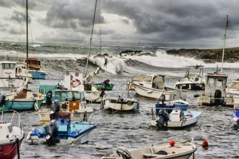 Un moment rare qui n'arrive que peu de fois. Une session de surf dans le port de Portivy. Profitant d'une tempête, un surfeur ganté (l'eau est froide) slalome entre les bateaux. Il y a peu de tirant d'eau à cet endroit, il faut donc être ..adroit.