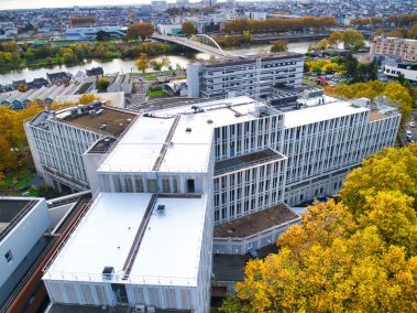 En plein automne, la société Isore Ouest vient de terminer de passer une couche de résine destinée à réfléchir les rayons solaires. Les arbres ont pris une teinte jaune-orangée. Dans le fond, le Pont "confluence" à Angers.