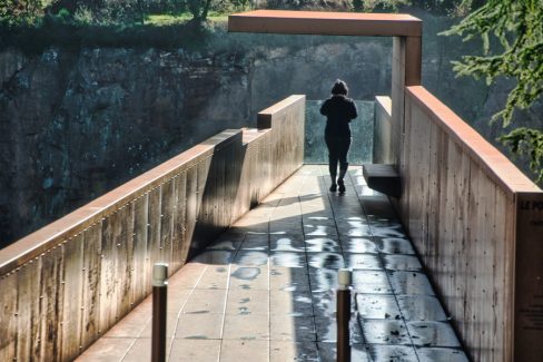 Une femme s'avance toute vêtue de noire, smartphone en avant sur le nouveau belvédère le "Porte-Vue" imaginé par Emmanuel Ritz et s'inscrivant dans le cadre du Voyage à Nantes vient d'ouvrir au public. De couleur rouille, il s'avance d'une vingtaine de mètres au dessus de la Maine et du site de Pont-Caffino connu pour le kayak et ses blocs d'escalade. Il invite à contempler la nature depuis la cime des arbres voire bien au-dessus.