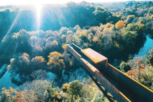 Le Porte-Vue dans le vignoble. Vue aérienne par drone du nouveau belvédère le "Porte-Vue" imaginé par Emmanuel Ritz et s'inscrivant dans le cadre du Voyage à Nantes vient d'ouvrir au public. De couleur rouille, il s'avance d'une vingtaine de mètres au dessus de la Maine et du site de Pont-Caffino connu pour le kayak et ses blocs d'escalade. Il invite à contempler la nature depuis la cime des arbres voire bien au-dessus.