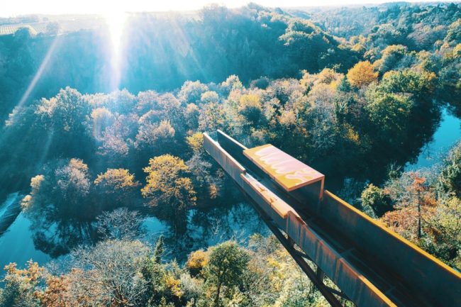 Blue Bel Le Porte-Vue dans le vignoble. Vue aérienne par drone du nouveau belvédère le "Porte-Vue" imaginé par Emmanuel Ritz et s'inscrivant dans le cadre du Voyage à Nantes vient d'ouvrir au public. De couleur rouille, il s'avance d'une vingtaine de mètres au dessus de la Maine et du site de Pont-Caffino connu pour le kayak et ses blocs d'escalade. Il invite à contempler la nature depuis la cime des arbres voire bien au-dessus.