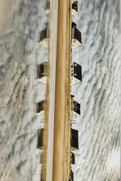 Des maisons typiquement bretonnes se reflètent dans l'océan atlantique à marée basse. Le ciel est cotonneux, et les toits noirs en ardoise se détachent du ciel pourtant chargé.