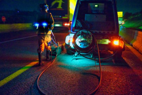Photographies de nuit d'un homme munit d'une machine servant à effacer les lignes de marquage au sol.