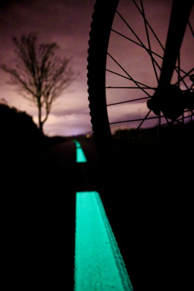 Un vélo parcourt une ligne photoluminescente. Il s'agit du nouveau produit élaboré par la société Miditraçage dénommé Vénus et destiné aux mobilités douces. Le pigment naturel se charge avec la lumière du jour et la restitue la nuit.