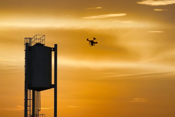 Un drone est en train d'évoluer au moment du coucher du soleil au Burkina Faso. Prises de vue afin de reconstituer un modèle 3D, et autres nuages de points d'un château d'eau.