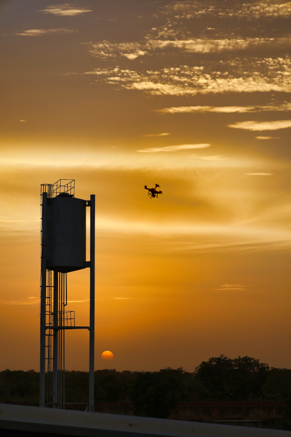 Un vol de drone dans le ciel Burkinabè Un drone est en train d'évoluer au moment du coucher du soleil au Burkina Faso. Prises de vue afin de reconstituer un modèle 3D, et autres nuages de points d'un château d'eau.