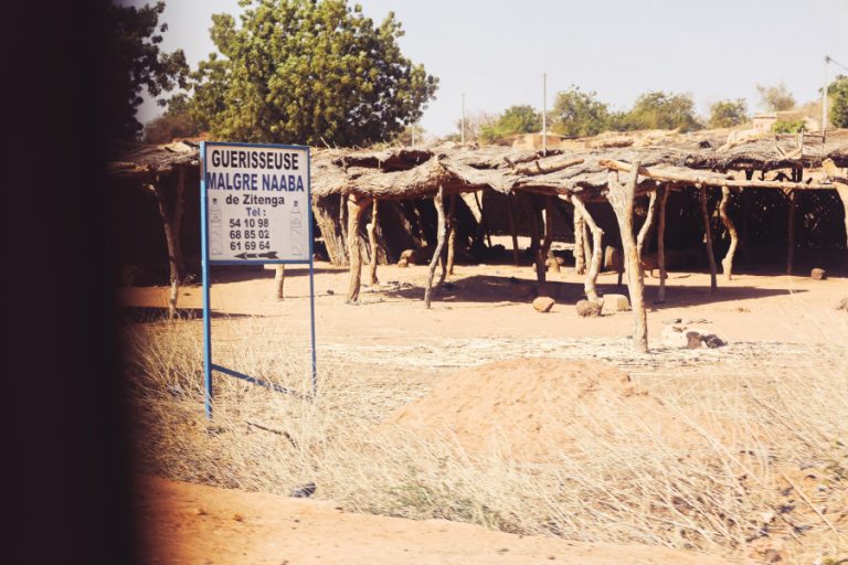 une pancarte annonce la présence d'une guérisseuse dans le secteur. Il va falloir s'arrêter pour la consulter.