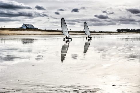 Nous sommes ici au niveau de l'isthme de la presqu'île de Quiberon, à Penthièvre plus précisément. Deux chars à voile profitent de la marée basse et d'un bon vent pour glisser sur l'estran.