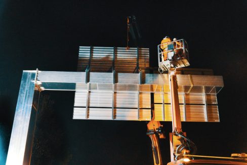 Une potence de plus d'une tonne vient d'être montée sur une des bretelles d'accès du périphérique nantais. Deux hommes sur une nacelle décrochent es sangles ayant servies au levage de cette potence.