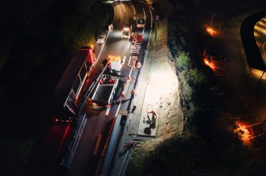 Prise de vue aérienne de nuit lors d'un suivi de chantier sur le périphérique nantais. Il faut pour cela les autorisations préfectorales ainsi que contacter l'aéroport. Des ouvriers se mettent en place avant le lever d'une potence de signalisation.