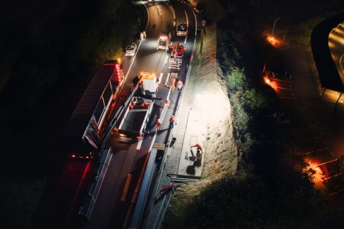 Prise de vue aérienne de nuit lors d'un suivi de chantier sur le périphérique nantais. Il faut pour cela les autorisations préfectorales ainsi que contacter l'aéroport. Des ouvriers se mettent en place avant le lever d'une potence de signalisation.