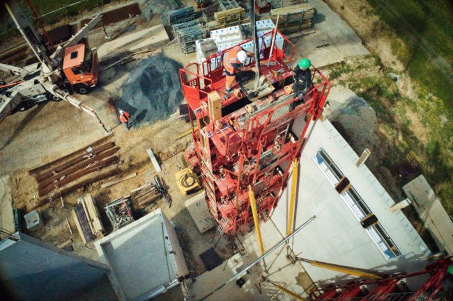 Photographie aérienne sur un chantier. Une tour est en construction. Des banches ont été installées afin de couler le béton matricé. Nous sommes à plus de 12 mètres de haut tout de même.