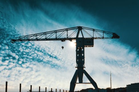 La grue Titan grise sous un ciel bleu cotonneux. Le soleil joue à cache-cache avec le géant de métal. C'est une des trois grues historiques de Nantes