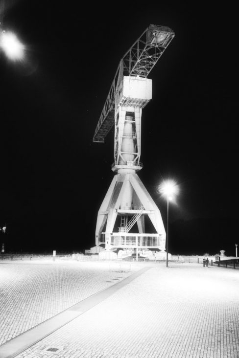 La grue Titan grise de nuit sur un quai des Antilles presque désert.