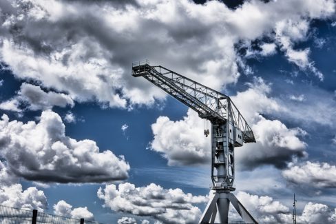 Notre grue Titan Grise sous les nuages à Nantes. Le ciel est rempli de moutons, de cumulus qui mettent en avant la majesté de cette grue historique de Nantes.