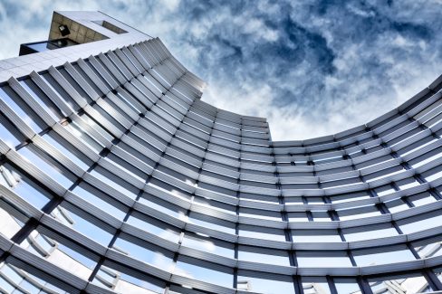 Un immeuble paré de nombreuses fenêtres et au bardage métallique semble d'élever vers l'infini